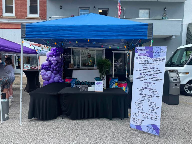 Pop & Pour Co. mobile bar setup with drink menu at a community event in St. Albans, WV