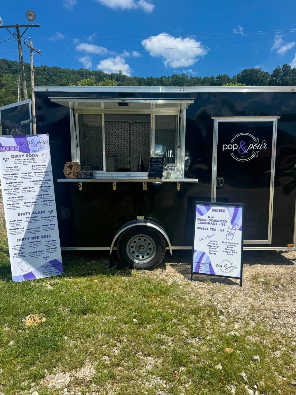 Pop & Pour Co. beverage trailer set up with drink menu displays at a West Virginia event